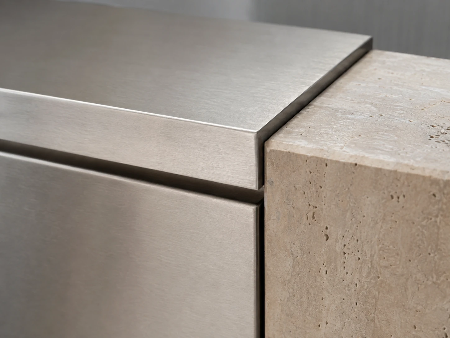 Brushed stainless steel and travertine material junction